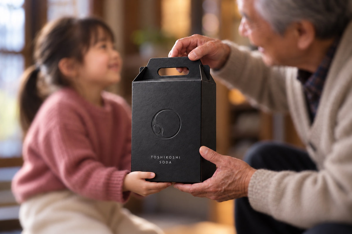 祖父から孫へ年越しソーダのギフトボックスを手渡す様子